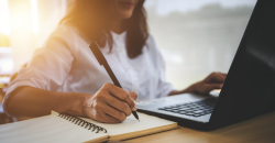 A woman writing on a notebook